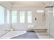 Bright bathroom featuring a corner bathtub, glass shower, tiled walls, and a modern marble bench at 2682 Boulder Creek Ne Dr, Roswell, GA 30075