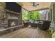 Covered patio with stacked stone fireplace, ceiling fan, outdoor seating area and forest view at 407 Estates View Dr, Acworth, GA 30101