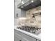 Kitchen features a gas range, stylish backsplash, and stainless steel vent hood at 407 Estates View Dr, Acworth, GA 30101