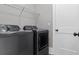 This laundry room has a side-by-side washer and dryer, a wire rack for storage, and a white door at 407 Estates View Dr, Acworth, GA 30101