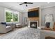 This cozy living room features a fireplace with a reclaimed wood accent wall and large light-filled windows at 407 Estates View Dr, Acworth, GA 30101