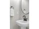 Elegant powder room with pedestal sink, modern faucet, and round mirror at 407 Estates View Dr, Acworth, GA 30101