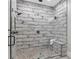 Contemporary walk-in shower featuring dual shower heads, pebbled floor, and stylish tiling at 407 Estates View Dr, Acworth, GA 30101