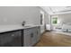 A wet bar with a built in Midea refrigerator, a solid surface countertop, and grey cabinetry is featured here at 407 Estates View Dr, Acworth, GA 30101