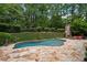 Backyard view of an in-ground pool, patio, outdoor fireplace and lush landscaping at 4101 Rickenbacker Ne Dr, Atlanta, GA 30342