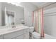 Cozy bathroom featuring a bathtub with shower, toilet, vessel sink, and a decorative mirror at 4101 Rickenbacker Ne Dr, Atlanta, GA 30342