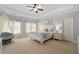 Spacious bedroom featuring a tray ceiling, plush carpeting, a comfortable bed, and abundant natural light at 4101 Rickenbacker Ne Dr, Atlanta, GA 30342