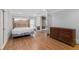Hardwood bedroom with a bed frame, wooden dresser, and sliding door leading to a small office space at 4101 Rickenbacker Ne Dr, Atlanta, GA 30342
