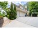 View of the home's exterior with a three-car garage and manicured landscaping at 4101 Rickenbacker Ne Dr, Atlanta, GA 30342
