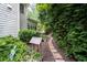 Exterior side yard with stone walkway, lush landscaping, and a wooded view at 4101 Rickenbacker Ne Dr, Atlanta, GA 30342