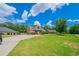 Charming brick home with lush green lawn and long driveway under a partly cloudy sky at 1480 Holly Brook Rd, Snellville, GA 30078