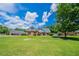 Inviting brick home featuring a beautifully manicured front yard under a partly cloudy sky at 1480 Holly Brook Rd, Snellville, GA 30078