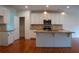 Well-lit kitchen with white cabinets, granite countertops, stainless steel appliances, and hardwood floors at 1777 Weatherbrook Cir, Lawrenceville, GA 30043