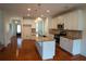 Stylish kitchen featuring white cabinets, granite countertops, stainless steel appliances, an island, and hardwood floors at 1777 Weatherbrook Cir, Lawrenceville, GA 30043
