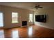 Bright and airy living room featuring a fireplace, hardwood floors, ceiling fan, and large windows at 1777 Weatherbrook Cir, Lawrenceville, GA 30043
