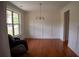 Bright living room boasting hardwood floors, wainscoting, large window, and a comfortable massage chair in the corner at 1777 Weatherbrook Cir, Lawrenceville, GA 30043