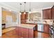Well-equipped kitchen featuring a granite island and stainless steel appliances that flows into the dining and living area at 3365 Buffington Ln, Cumming, GA 30040
