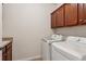 Laundry room with front load washer and dryer and dark wood cabinets above the machines at 3365 Buffington Ln, Cumming, GA 30040