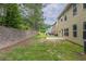 A spacious, grassy backyard featuring a concrete patio with a stone retaining wall at 3399 Lake Frg, Fairburn, GA 30213