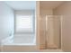 Bathroom featuring a soaking tub and glass-enclosed shower at 3399 Lake Frg, Fairburn, GA 30213