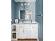 Bathroom featuring double sinks, a large mirror, modern vanity, and sleek blue walls at 4568 Oswood Ct, Tucker, GA 30084