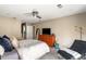 Spacious bedroom with a ceiling fan, grey carpet, chaise lounge, and orange dresser with tv at 4568 Oswood Ct, Tucker, GA 30084