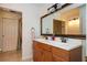 Bright bathroom featuring double vanity with white countertops, a framed mirror, and a door to a shower at 5102 Chastleton Dr, Stone Mountain, GA 30087