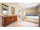 Bathroom featuring double sinks, jacuzzi, and natural stone tile flooring at 5102 Chastleton Dr, Stone Mountain, GA 30087