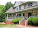 Beautiful two-story home with a wraparound porch, manicured lawn, and lush landscaping at 5102 Chastleton Dr, Stone Mountain, GA 30087