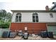 Rear exterior of home with brick foundation, white siding, and arched windows at 5102 Chastleton Dr, Stone Mountain, GA 30087