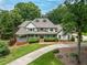 Stately two-story home with a covered porch, mature trees, lush landscaping, and a circular driveway at 5102 Chastleton Dr, Stone Mountain, GA 30087