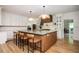 Open-concept kitchen with a large island featuring seating, custom cabinets, and modern lighting at 5102 Chastleton Dr, Stone Mountain, GA 30087