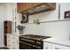Modern kitchen featuring custom cabinetry, a professional gas range, and decorative lighting at 5102 Chastleton Dr, Stone Mountain, GA 30087