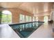 Beautiful indoor pool showcasing its stunning wood-paneled ceiling and large arched windows for natural lighting at 5102 Chastleton Dr, Stone Mountain, GA 30087