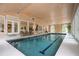 Long, spacious indoor pool with tiled trim and view into another room with comfortable seating at 5102 Chastleton Dr, Stone Mountain, GA 30087