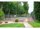 Outdoor tennis court surrounded by lush greenery and a chain-link fence at 5102 Chastleton Dr, Stone Mountain, GA 30087