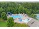 Aerial view of the community pool, slide, and lounging area surrounded by tennis courts and trees at 5880 Crestwick Way, Cumming, GA 30040