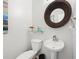 Cozy half bathroom with sleek pedestal sink, decorative mirror, and modern fixtures at 5880 Crestwick Way, Cumming, GA 30040