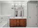 Bright bathroom features double sink vanity, large mirror, and modern lighting fixtures at 5880 Crestwick Way, Cumming, GA 30040