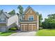 Two-story home featuring a well-manicured lawn and a two-car garage at 5880 Crestwick Way, Cumming, GA 30040