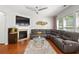 Inviting living room with fireplace, TV, leather sofa, and bright windows at 5880 Crestwick Way, Cumming, GA 30040