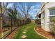 Backyard lawn featuring a stone paver path, lush landscaping, and iron fencing at 2502 Oak Hill Ovlk, Duluth, GA 30097