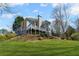 Spacious backyard with lush lawn and mature trees, showcasing the home's upper and lower rear balconies at 2502 Oak Hill Ovlk, Duluth, GA 30097