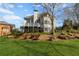 Elevated backyard with lush lawn, wrought iron fencing, tiered garden beds, and back exterior of home at 2502 Oak Hill Ovlk, Duluth, GA 30097