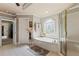 Bright bathroom featuring a soaking tub, separate shower, and tile flooring at 2502 Oak Hill Ovlk, Duluth, GA 30097