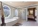 Bright bathroom featuring a soaking tub, separate shower, and tile flooring at 2502 Oak Hill Ovlk, Duluth, GA 30097