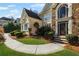An attractive residence showcasing a stone-accented facade, arched doorway, meticulously maintained lawn, and lush foliage at 2502 Oak Hill Ovlk, Duluth, GA 30097