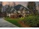Attractive two-story home featuring a stone facade, arched entryway, well-manicured lawn, and mature landscaping at 2502 Oak Hill Ovlk, Duluth, GA 30097