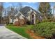Attractive two-story home featuring a stone facade, arched entryway, well-manicured lawn, and mature landscaping at 2502 Oak Hill Ovlk, Duluth, GA 30097