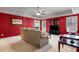 Bright living room featuring a red accent wall, neutral sofa, and modern decor at 2502 Oak Hill Ovlk, Duluth, GA 30097
